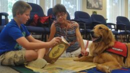 L’interazione con un animale è qualcosa di estremamente benefico e positivo per l’essere umano, Lo dimostrano gli enormi passi avanti che fanno i pazienti che vengono inseriti in programmi di pet-therapy; ma anche in soggetti che non presentino disagi psichici patologie la relazione con un animale è positiva perché permette di migliorare il rapporto con se stessi in relazione ad un altro essere vivente attraverso una modalità comunicativa del tutto nuova. La zooantropologia si occupa proprio di questo: la relazione uomo-animale e le capacità migliorative della persona attraverso quest’interazione. La zooantropologia didattica è uno degli ambiti applicativi e si sofferma su aspetti naturalistici, ecologici, zooantropologici, sanitari e cognitivi rivolgendosi ai bambini ed ai ragazzi a scuola (dalla scuola dell’infanzia a quella secondaria). Gli obiettivi della zooantropologia didattica sono molteplici ed includono diversi ambiti. Infatti a livello disciplinare si cerca di trasmettere le caratteristiche specifiche dei diversi animali insegnando a relazionarsi ad essi; l’aspetto educativo invece mira allo sviluppo di una conoscenza di sé per favorire autocontrollo, empatia e capacità cognitive; infine gli obiettivi didattici hanno come scopo l’inclusione, anche di bambini o ragazzi con difficoltà o disturbi al fine di favorirne la partecipazione alla vita scolastica e alle dinamiche di gruppo. Storicamente il valore della relazione uomo-animale risale alle ricerche scientifiche svolte a partire dagli anni ‘50 ad opera dello psicologo americano Samuel Ross che in qualità di fondatore di una comunità di recupero per bambini con difficoltà di inserimento sociale si serviva di attività basate sulla “pet-relationship” affinché i bambini sviluppassero un senso di accudimento e cura nei confronti degli animali da utilizzare poi nella propria vita. Negli anni ‘60 la semplice presenza di un cane durante le sedute terapeutiche con ragazzi autistici ad opera dello psichiatra Boris Levinson favoriva la relazionalità dei pazienti. Numerose sono state e sono tuttora le ricerche svolte in quest’ambito, senza considerare i dettami di Konrad Lorenz, il padre dell’etologia, che in prima persona sperimentò la forza del legame di attaccamento con un animale ed in particolare dell’imprinting a dimostrare quanto potesse essere forte, naturale e fruttuosa la relazione uomo-animale. Andando avanti negli anni sulla scorta di queste scoperte diverse considerazioni sono state fatte sull’inclusione degli animali in percorsi di crescita ciò nondimeno ha favorito l’estensione di questa tipologia di relazione anche in ambito formativo. In Italia le ricerche sulla relazione uomo-animale ed i suoi ambiti di applicazione sono molto attive. Il ruolo che viene riconosciuto all’animale è importante al fine di una buona resa dell’approccio didattico della zooantropologia. Esso infatti viene percepito come un altro soggetto con cui entrare in relazione così che il bambino possa sperimentare una nuova relazione che al suo interno contempla modalità diverse rispetto a quelle tra gli esseri umani. La diversità dell’animale esercita un forte fascino sul bambino ed è considerato più vicino a lui rispetto al mondo degli adulti (forse per il grado di dipendenza o di giocosità che trasmette); nonché le sue molteplici capacità comunicative che passano tutte attraverso la comunicazione non verbale. La capacità dell’animale di tranquillizzare il bambino è riconosciuta ed attraverso questa egli si sente più libero di esprimersi; anche la curiosità del bambino viene fortemente stimolata dalla diversità, soprattutto in fase di stimolo-risposta. Infine spesso l’animale assolve alla funzione di base sicura per lo sviluppo dell’affettività del bambino. Attraverso progetti mirati quindi si vuole favorire questa conoscenza, relazione, interazione al fine di migliorare lo sviluppo psicologico del bambino e favorirne la crescita. Un progetto messo in atto qualche anno fa in una scuola primaria dell’Emilia ha permesso di implementare le conoscenze e le interazioni con un animale, nello specifico il cane che bene si presta a questo tipo di processo. L’obiettivo di fornire al bambino le capacità di interagire in modo lineare con l’animale è stato messo in atto attraverso diverse fasi; inoltre si è cercato di trasmettere attraverso un senso della relazione la capacità di dare i giusti significati ai messaggi senza equivocare la comunicazione e le sue peculiarità. Questo confronto favorisce la nascita e lo sviluppo dell’empatia nel bambino che si ripercuote sulla strutturazione della personalità e del comportamento. Gli obiettivi, come detto, sono molteplici: comunicativi, educativi, didattici, informativi, relazionali che alla fine, attraverso le varie sfaccettature del bambino e dell’animale verranno accorpati in un unicum che caratterizzerà un aspetto molto forte della personalità del bambino. È importante trasmettere ai bambini l’idea che esistono vari modi di comunicare, uno di questi è la comunicazione non verbale che spesso ha più effetto sull’animale e rappresenta l’interpretazione dei segnali corporei che tutti mettiamo in atto: uomini ed animali. In questo ambito è necessario dare delle informazioni ai bambini circa i segnali emessi dai cani, in particolare i “segnali di calma” che servono nei cani a prevenire i conflitti o a risolverli in modo pacifico: leccarsi il naso, guardare lontano, mostrare il fianco o la schiena, sbadigliare, annusare, strizzare gli occhi o alzare la zampa, ecc. Un’altra componente importante è l’approccio con il cane; è infatti importante che il bambino impari a rispettare i tempi dell’animale per evitare di spaventarlo e che impari a mediare tra i suoi istinti e quelli di chi ha di fronte; l’uso di una modalità comunicativa ad hoc favorisce senz’altro questo momento. La relazione con l’animale è basata anche sul riconoscimento dei suoi bisogni e la soddisfazione di essi, in questo caso oltre a sviluppare un senso di cura nel bambino, lo si stimola anche a livello cognitivo e senso-motorio. Infine nell’incontro reale tra bambino e cane si valuta quanto le aspettative del bambino corrispondano alla realtà, quanto egli sarà in grado di mettersi in discussione e quanto avrà appreso durante le attività precedenti. Per approfondire: G. Ottogalli (a cura di) “La relazione bambino-animale a scuola. Progetti di zooantropologia didattica in due scuole dell’Emilia” in “Psicologia e scuola” anno 29°, Gen-Feb 2009, n.1, pp.58-61 © Dott. Pasquale Saviano Psicologo – Psicoterapeuta